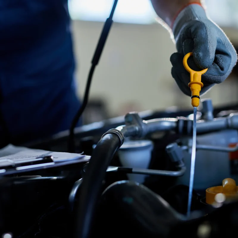 closeup-auto-repairman-checking-car-oil-workshop